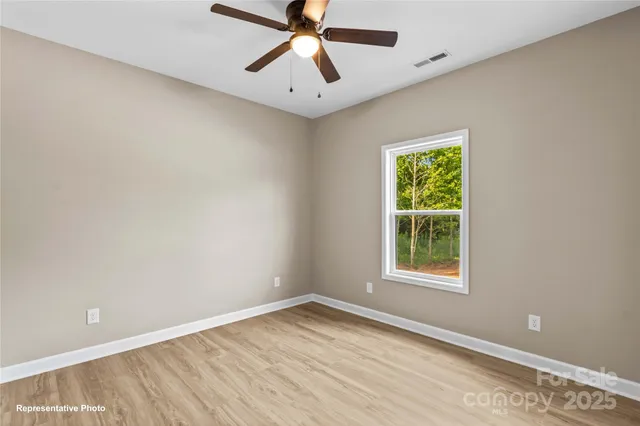 an empty room with a window and a fan