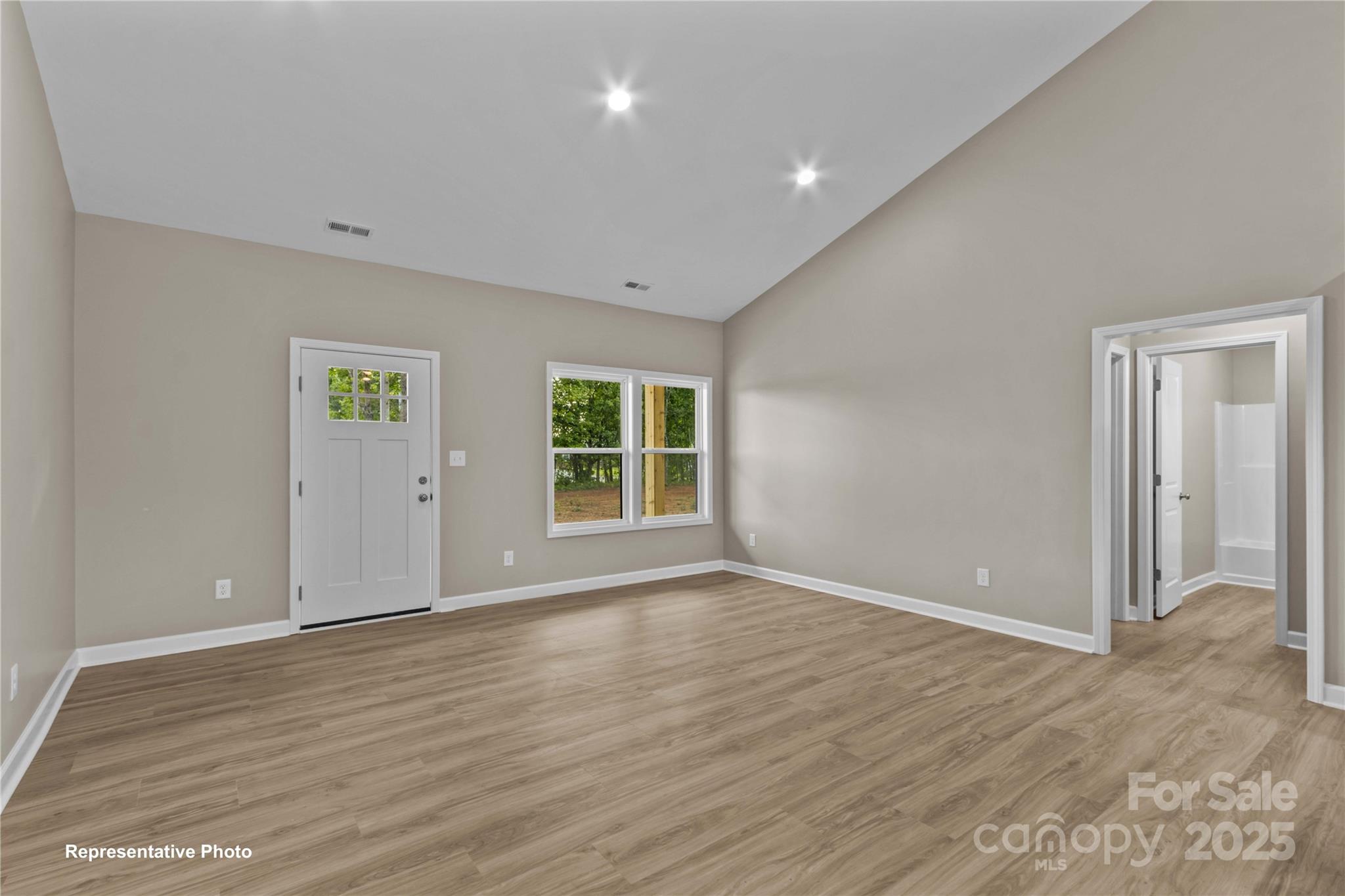 986 Tabor Road Olin, NC 28660 - Photo 2 of 27 a view of an empty room with wooden floor and windows