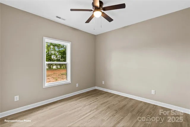 an empty room with a window and a fan