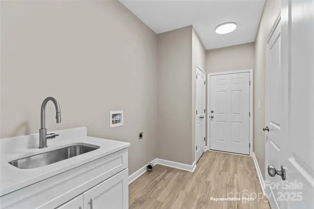a view of a sink storage and utility room with closet