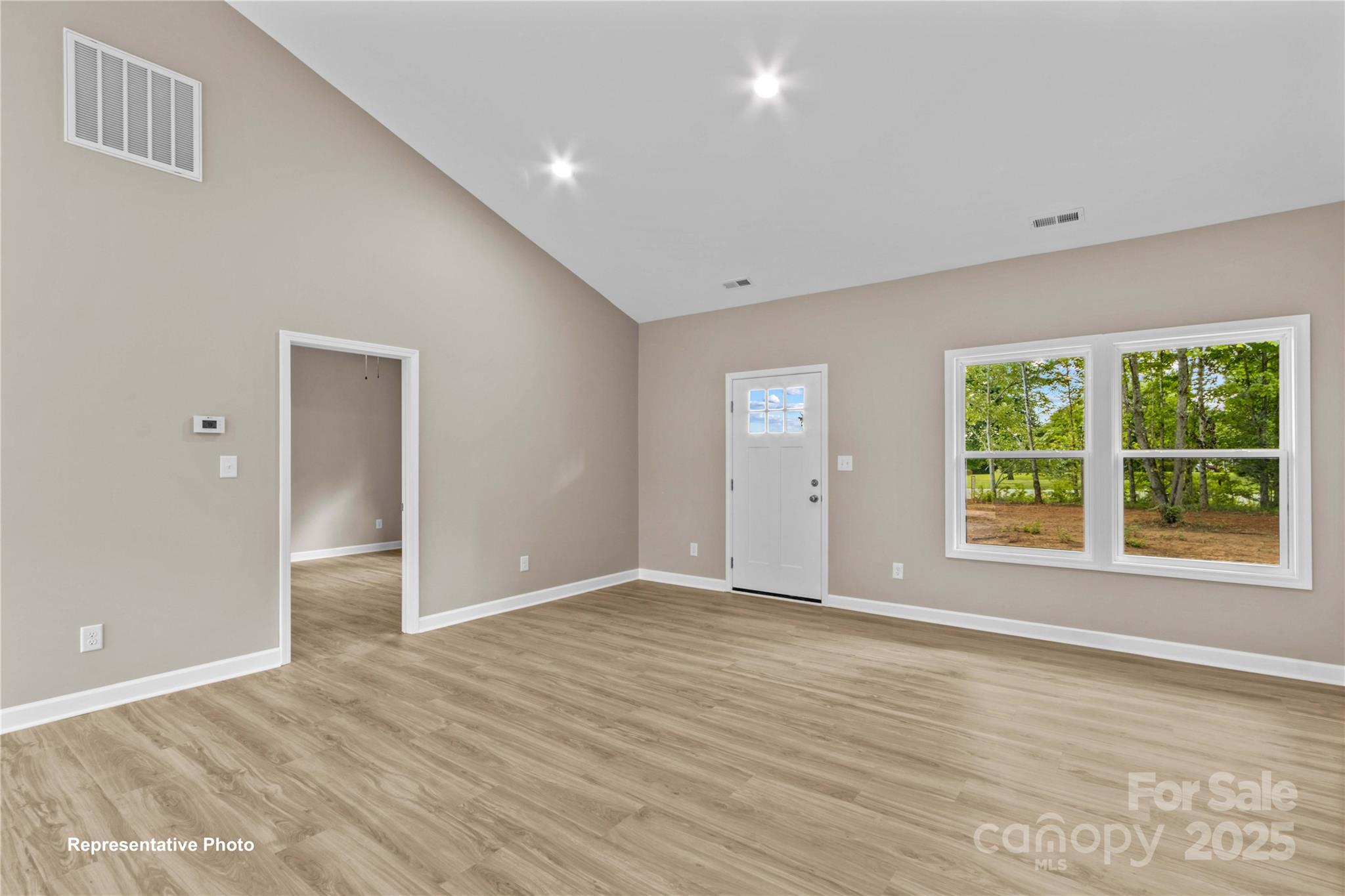 986 Tabor Road Olin, NC 28660 - Photo 3 of 27 a view of an empty room with wooden floor and a window