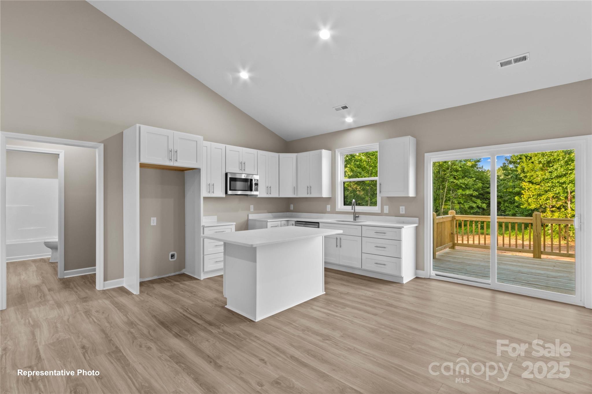 986 Tabor Road Olin, NC 28660 - Photo 8 of 27 a kitchen with white cabinets and wooden floor