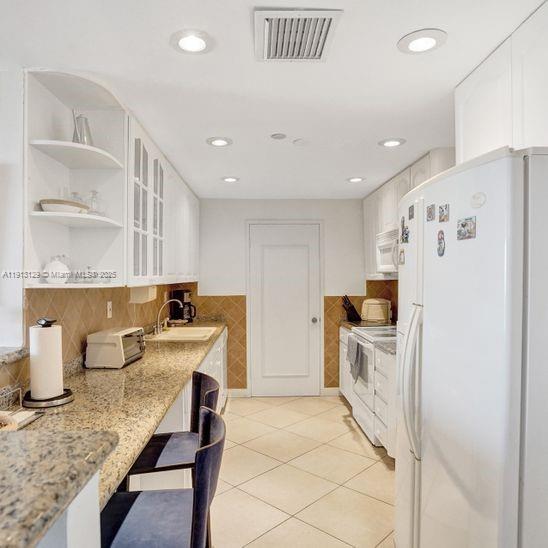 151 Crandon Boulevard, Unit 1130 Key Biscayne, FL 33149 - Photo 11 of 39 a kitchen with refrigerator and cabinets