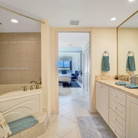 a bathroom with a tub sink and mirror