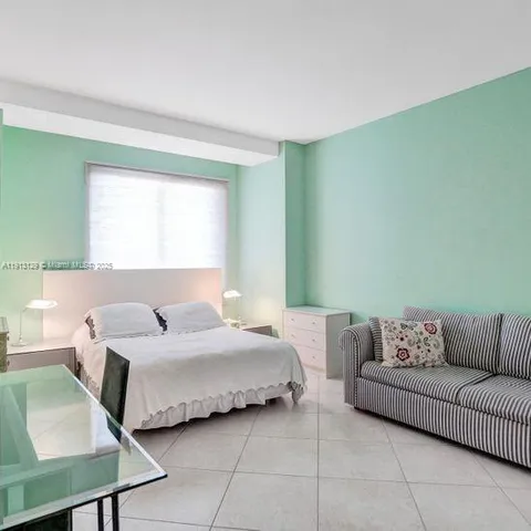 a bedroom with a bed couch and window