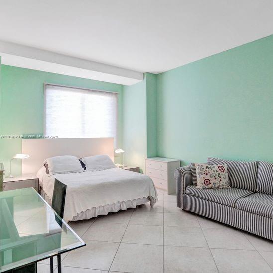 151 Crandon Boulevard, Unit 1130 Key Biscayne, FL 33149 - Photo 24 of 39 a bedroom with a bed couch and window