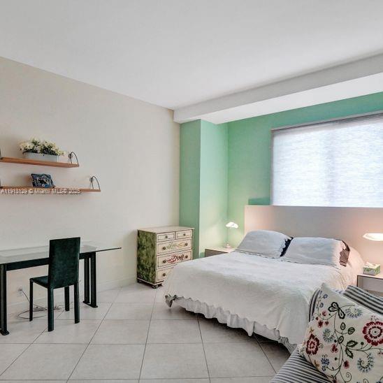 151 Crandon Boulevard, Unit 1130 Key Biscayne, FL 33149 - Photo 25 of 39 a bedroom with a bed and a table in it
