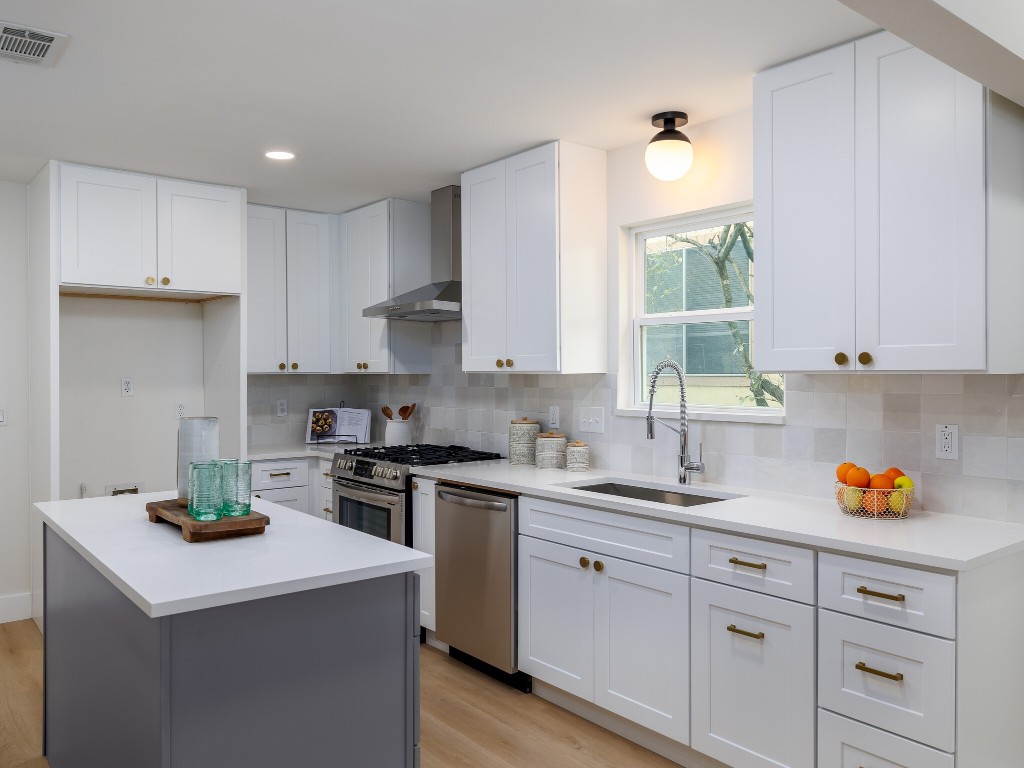 a kitchen with a sink white cabinets and white appliances