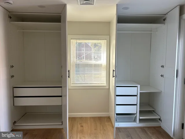 a view of walk in closet with empty racks
