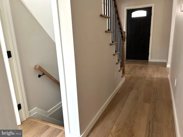 a view of a hallway with wooden floor and staircase