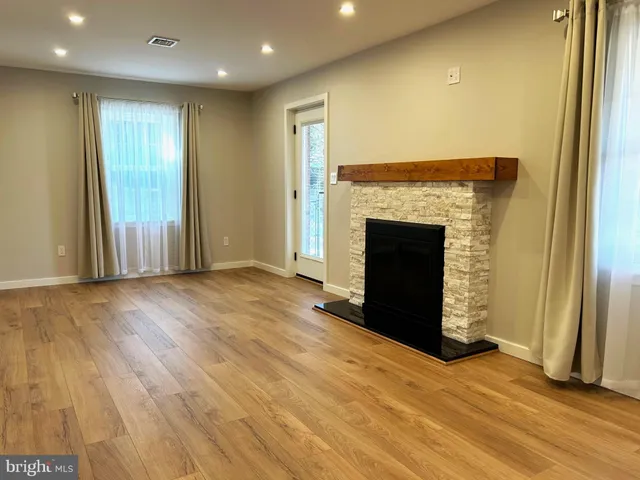 an empty room with wooden floor and fireplace
