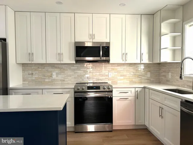a kitchen with white cabinets and a sink