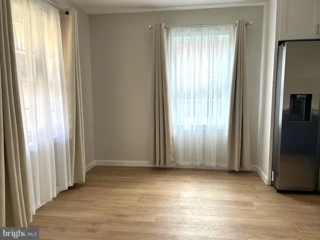 an empty room with wooden floor and a window