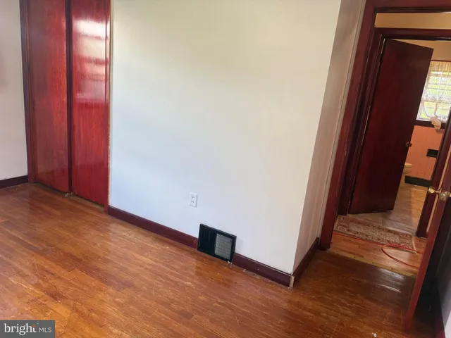 an empty room with wooden floor and stairs