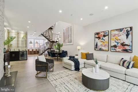 a living room with furniture kitchen view and a large window