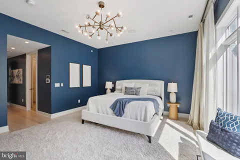 a bedroom with a bed and large windows