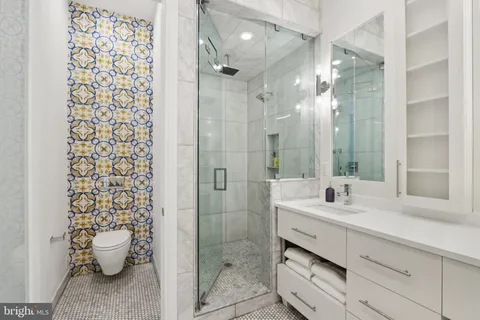 a bathroom with a sink a toilet and shower