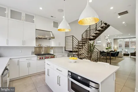 a kitchen with a sink a stove and chairs