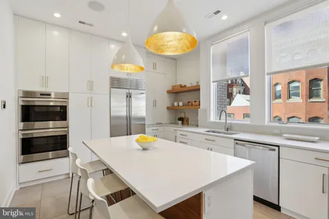 a kitchen with stainless steel appliances a stove a sink and a refrigerator