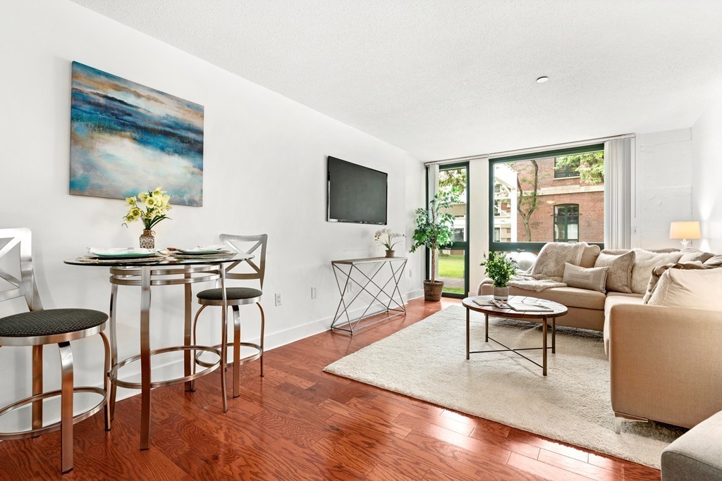 42 8th Street, Unit 5109 Boston, MA 02129 - Photo 4 of 17 a living room with furniture and a flat screen tv with wooden floor