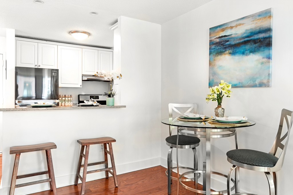 42 8th Street, Unit 5109 Boston, MA 02129 - Photo 8 of 17 a kitchen with stainless steel appliances kitchen island granite countertop a dining table chairs and a refrigerator