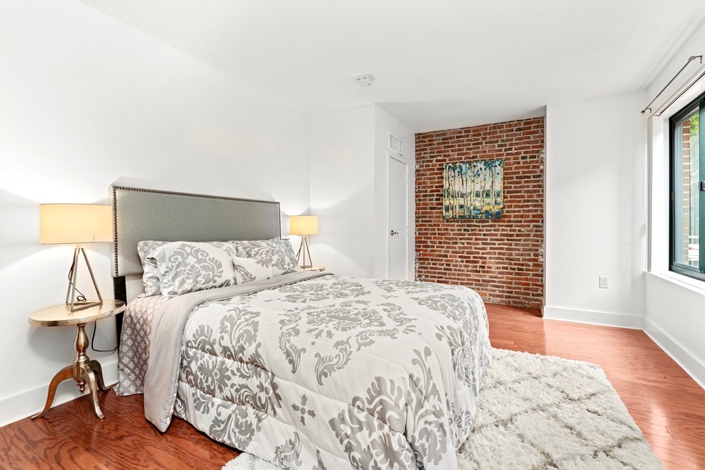 42 8th Street, Unit 5109 Boston, MA 02129 - Photo 9 of 17 a bedroom with a bed and wooden floor