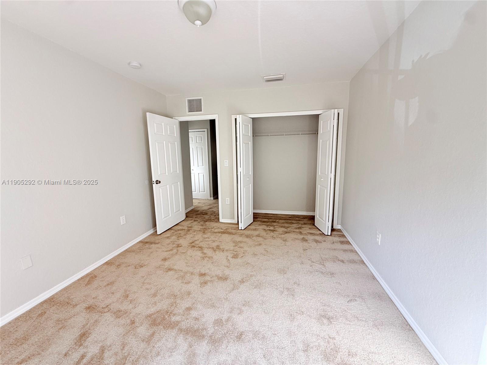 656 Southwest 11th Street, Unit 656 Florida City, FL 33034 - Photo 13 of 18 an empty room with closet and wooden floor