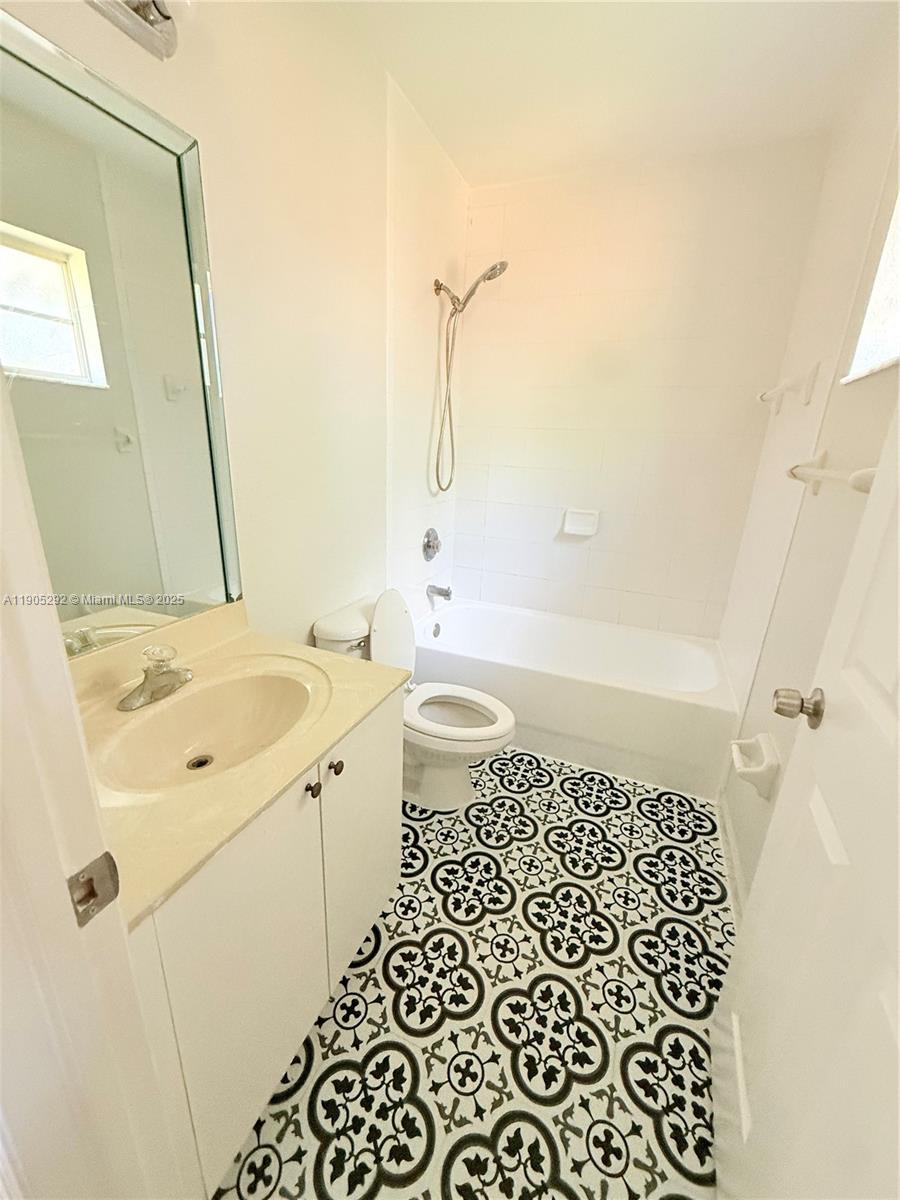 656 Southwest 11th Street, Unit 656 Florida City, FL 33034 - Photo 15 of 18 a bathroom with a granite countertop sink a toilet and shower