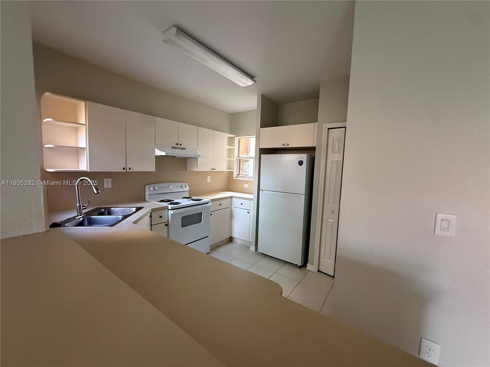656 Southwest 11th Street, Unit 656 Florida City, FL 33034 - Photo 2 of 18 a kitchen with a refrigerator a stove a sink dishwasher and a refrigerator with wooden floor
