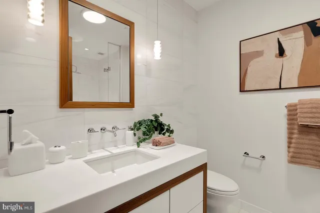 a bathroom with a sink mirror and toilet