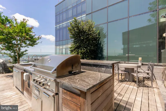 a roof deck with a table and chairs and potted plants