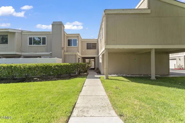 a view of a house with a yard and a tree