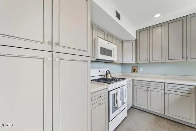 a kitchen with granite countertop white cabinets and a sink