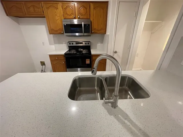 a kitchen with a sink a microwave and cabinets