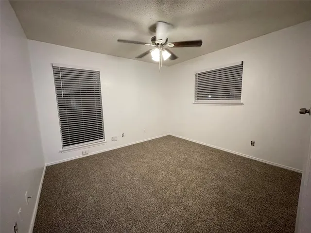 a view of a livingroom with a ceiling fan and window