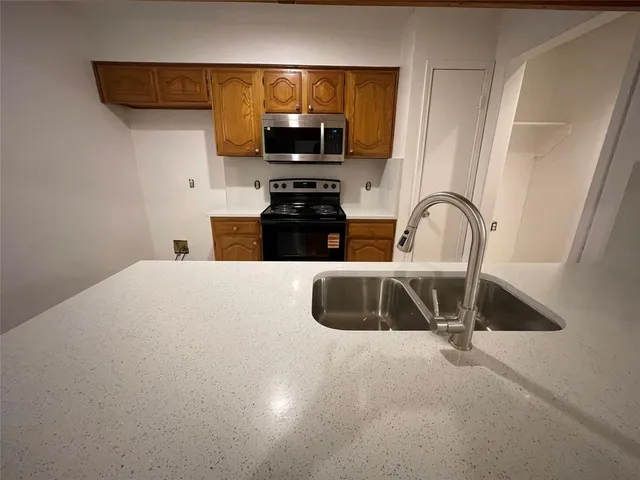 a kitchen with a sink a stove and a microwave