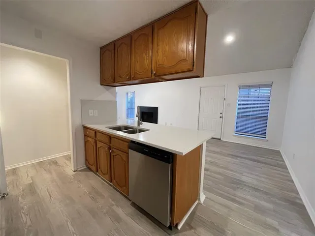 a kitchen with granite countertop wooden cabinets and a wooden floor