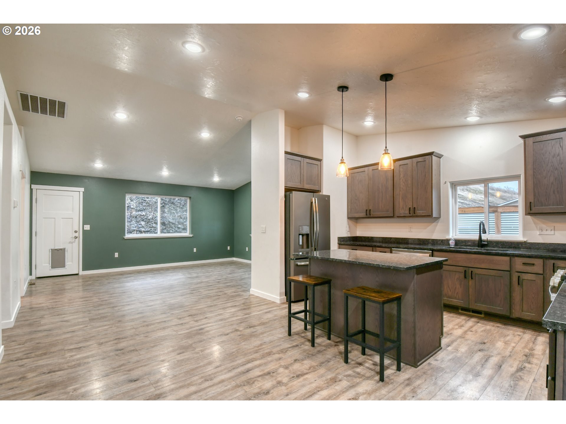 2010 Tutuilla Road Pendleton, OR 97801 - Photo 5 of 38 a open kitchen with stainless steel appliances granite countertop a stove top oven a sink dishwasher a dining table and chairs with wooden floor
