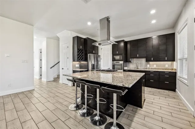 a kitchen with stainless steel appliances kitchen island granite countertop a sink and cabinets