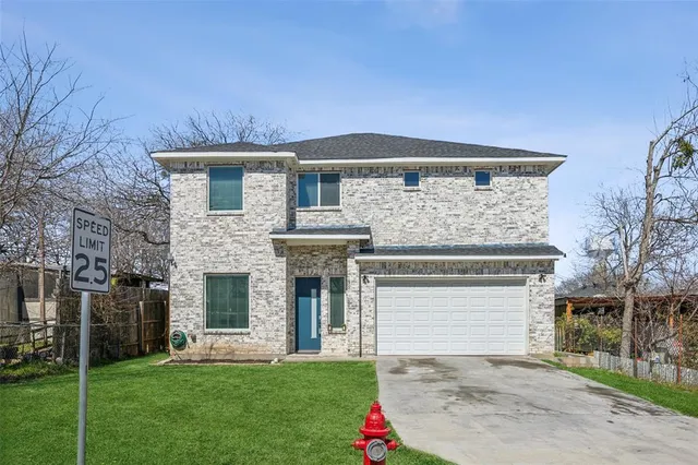 a front view of a house with a garden and yard