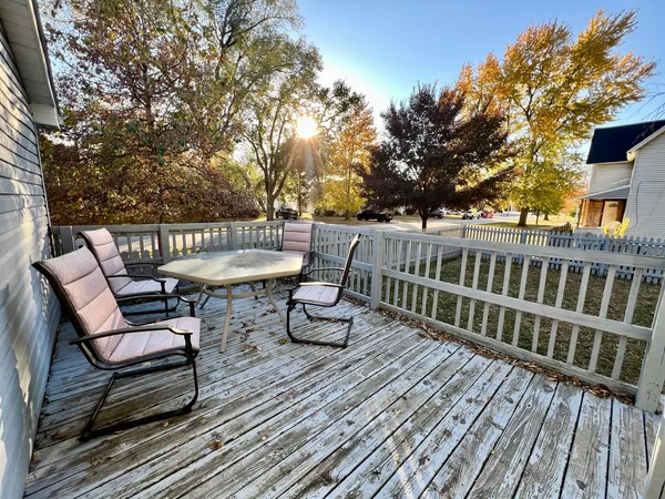 a view of a roof deck with table and chairs and wooden floor