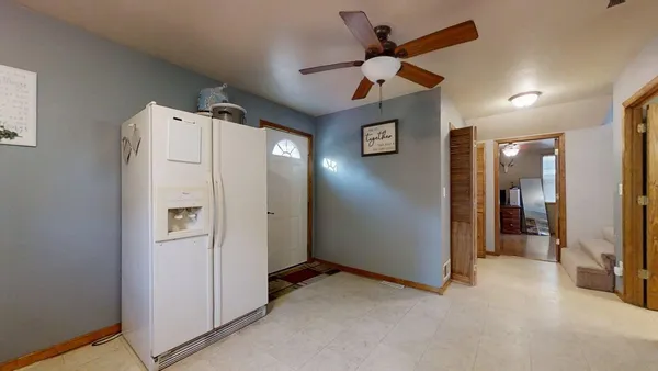 a view of a livingroom with a chandelier fan and refrigerator