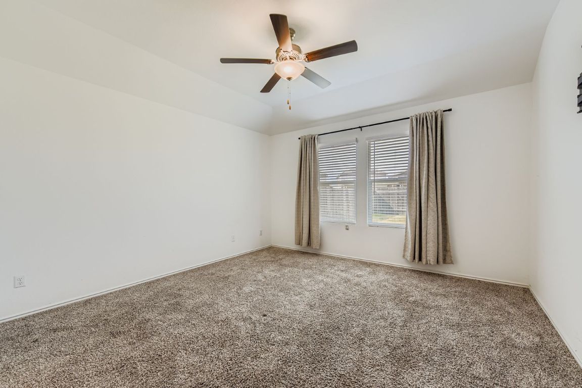 210 Montego Street Hutto, TX 78634 - Photo 14 of 29 an empty room with fan and windows