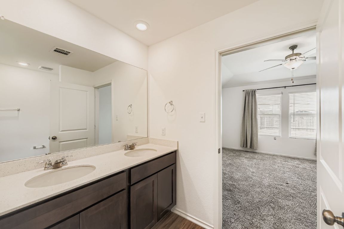 210 Montego Street Hutto, TX 78634 - Photo 17 of 29 a bathroom with a double vanity sink mirror and next to a window