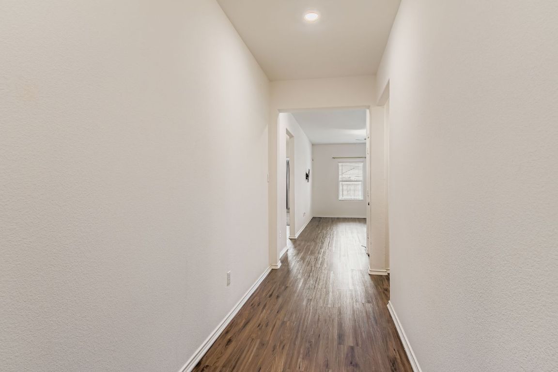 210 Montego Street Hutto, TX 78634 - Photo 5 of 29 a view of a hallway with wooden floor