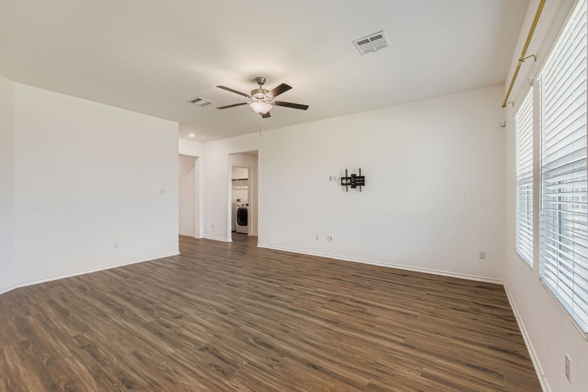 210 Montego Street Hutto, TX 78634 - Photo 8 of 29 wooden floor in an empty room with a window