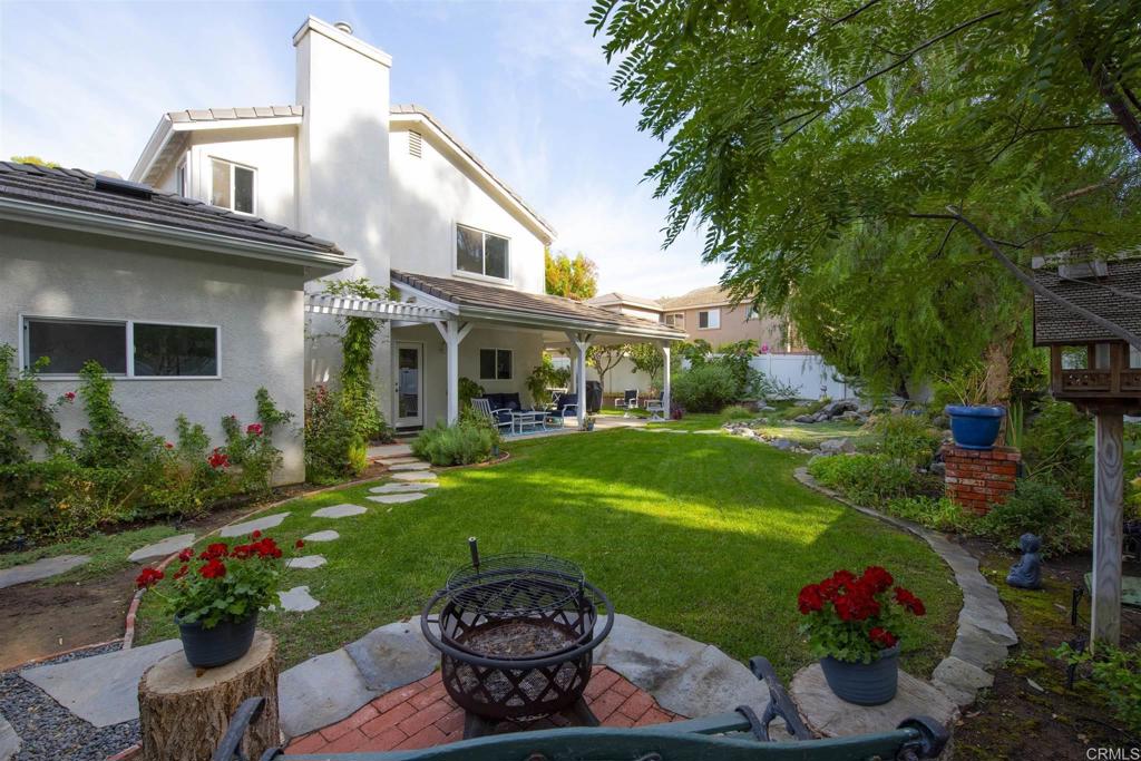 1677 Mission Meadow Drive Oceanside, CA 92057 - Photo 31 of 48 a front view of a house with a garden and plants