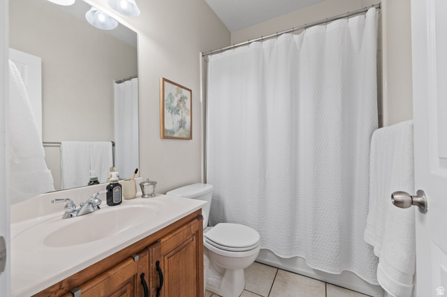 6208 West Bull River Road Highland, UT 84003 - Photo 42 of 90 Bathroom featuring a wood-finish vanity with a white countertop and integrated sink, a toilet, and a shower/tub combination with a white shower curtain