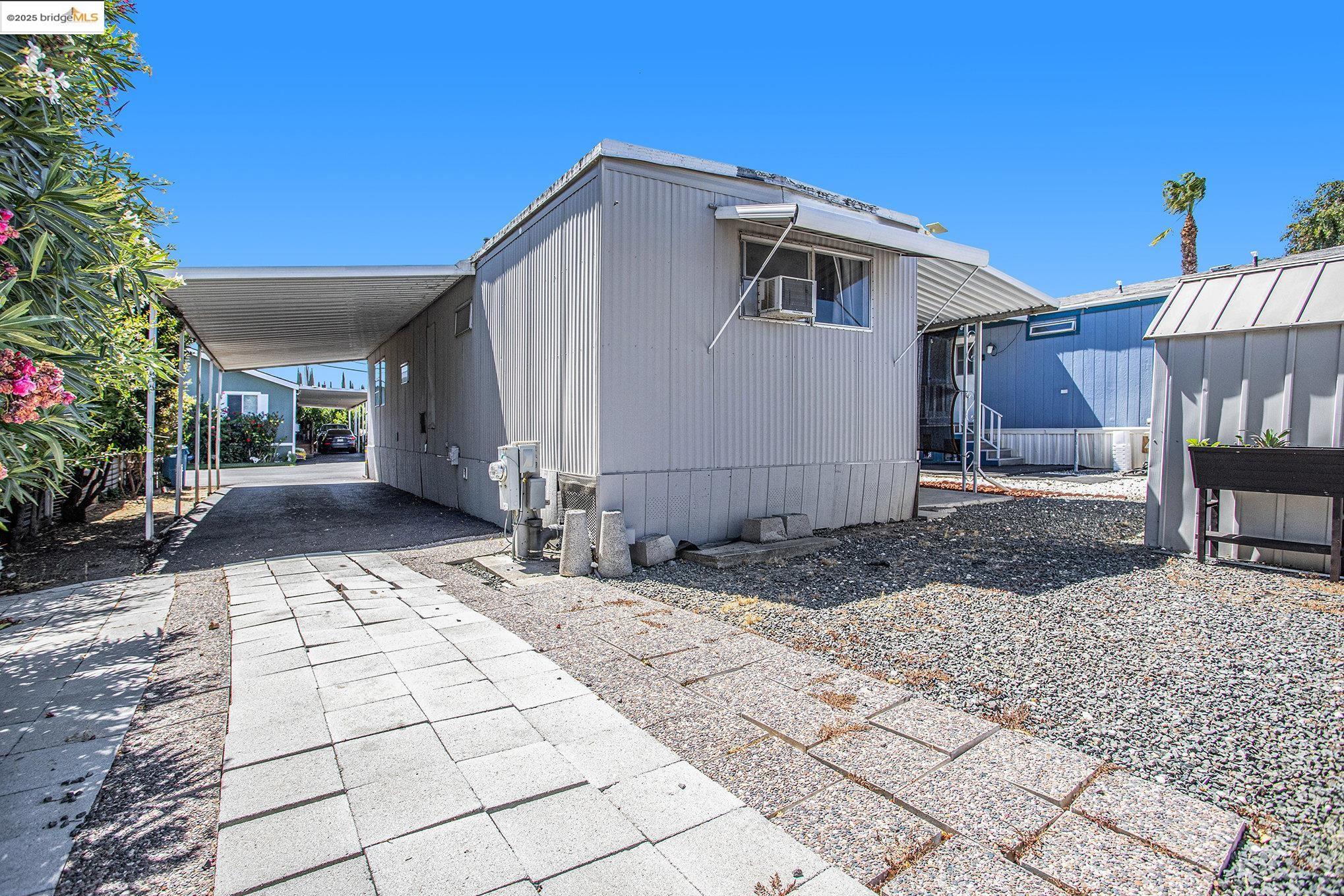 3301 Buchanan Road, Unit 118 Antioch, CA 94509 - Photo 12 of 15 View of side of property featuring an attached carport and driveway