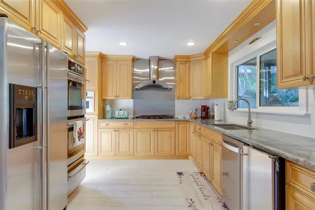 a kitchen with stainless steel appliances granite countertop a refrigerator and a stove top oven